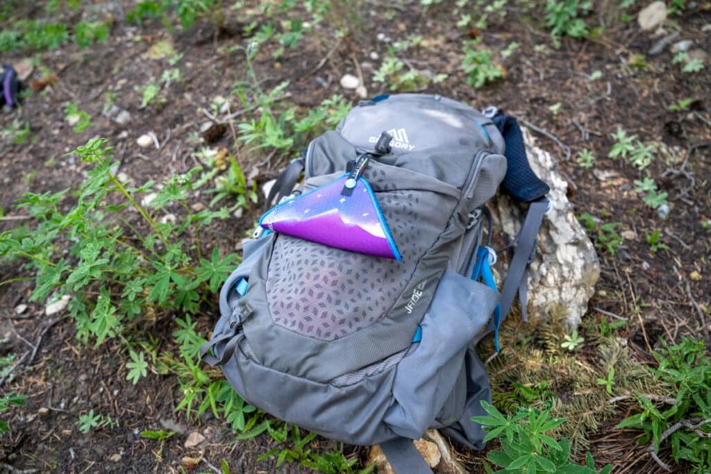 Kula Cloth pee rag hanging on the outside of a hiking backpack