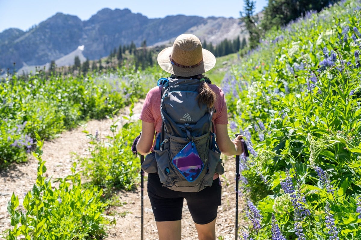 Kristen Bor hiking with a Kula Cloth pee rag hanging on the outside of a hiking backpack