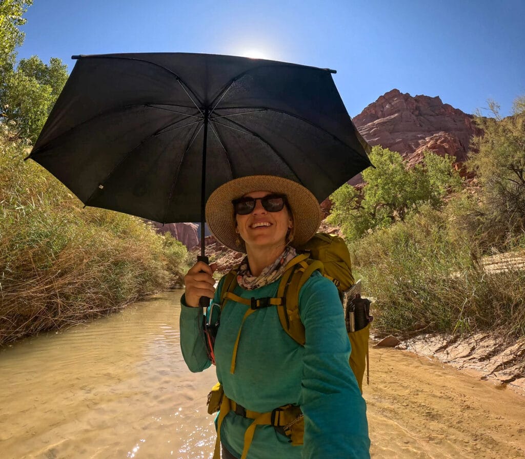 Kristen Bor standing under the six moons hiking umbrella in Paria Canyon