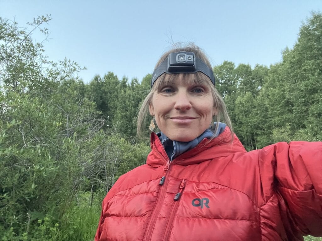 Kristen Bor at a campsite wearing a headlamp