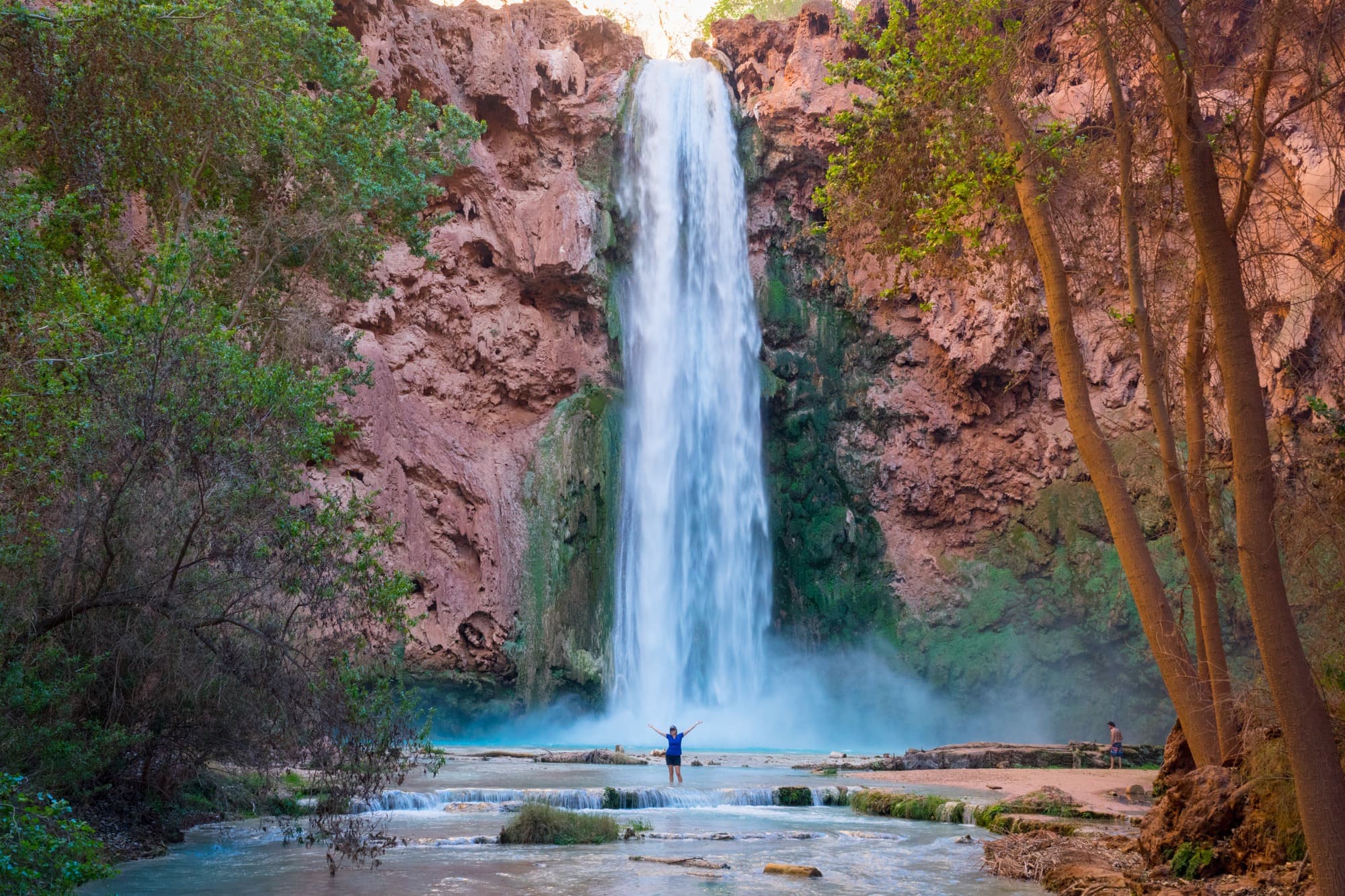 Person standing at the base of Mooney Falls