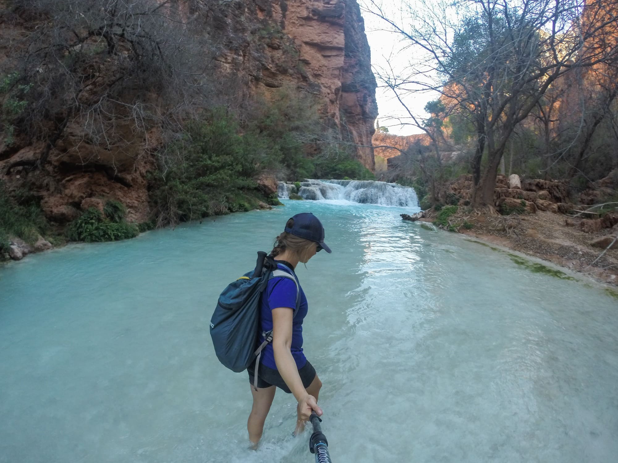 Kristen Bor holding a selfie stick while crossing Havasu Creek